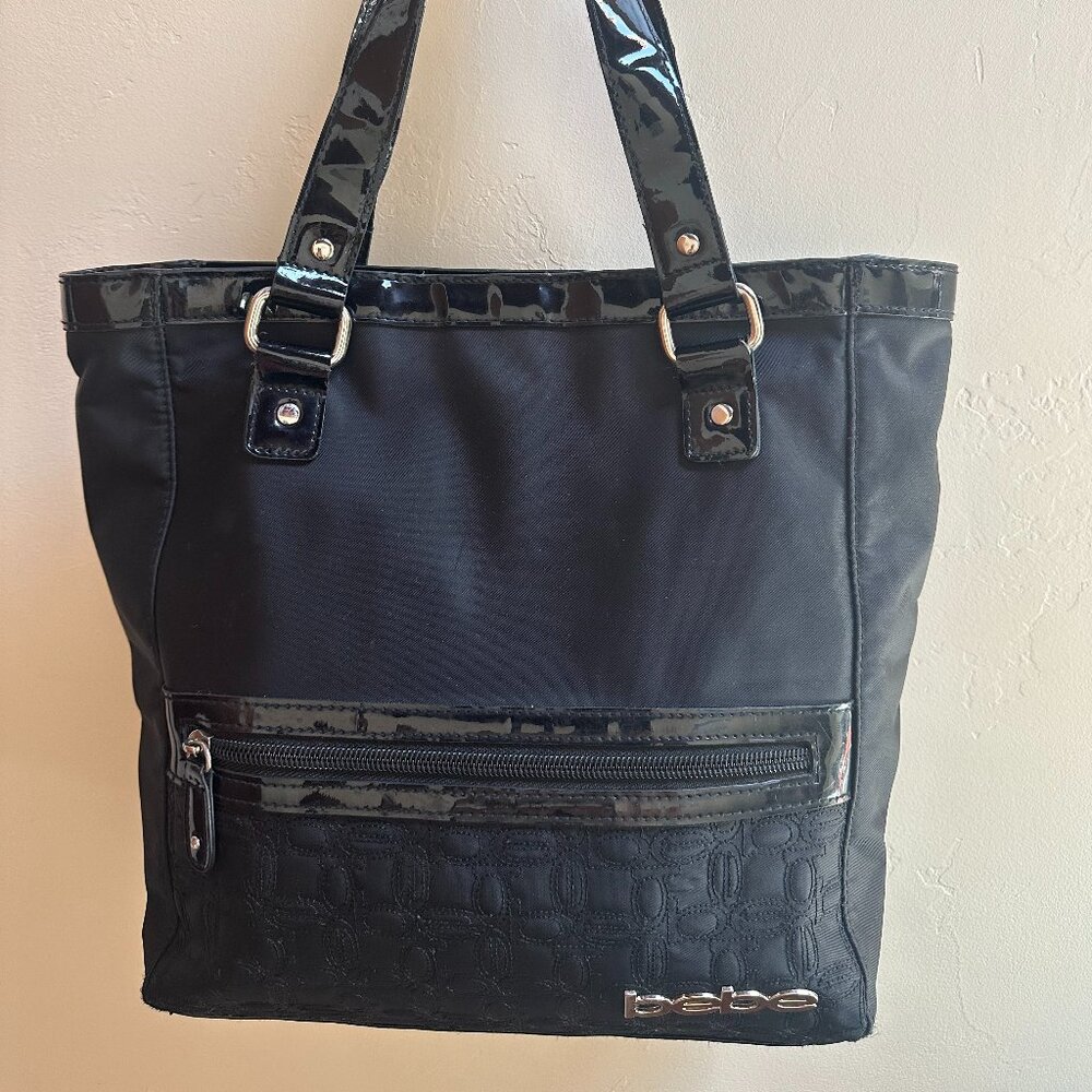 bebe Black handbag with silver logo and magnet closure.  Outside zipper.